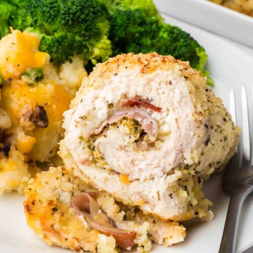 a sliced chicken rollatini on a plate with broccoli