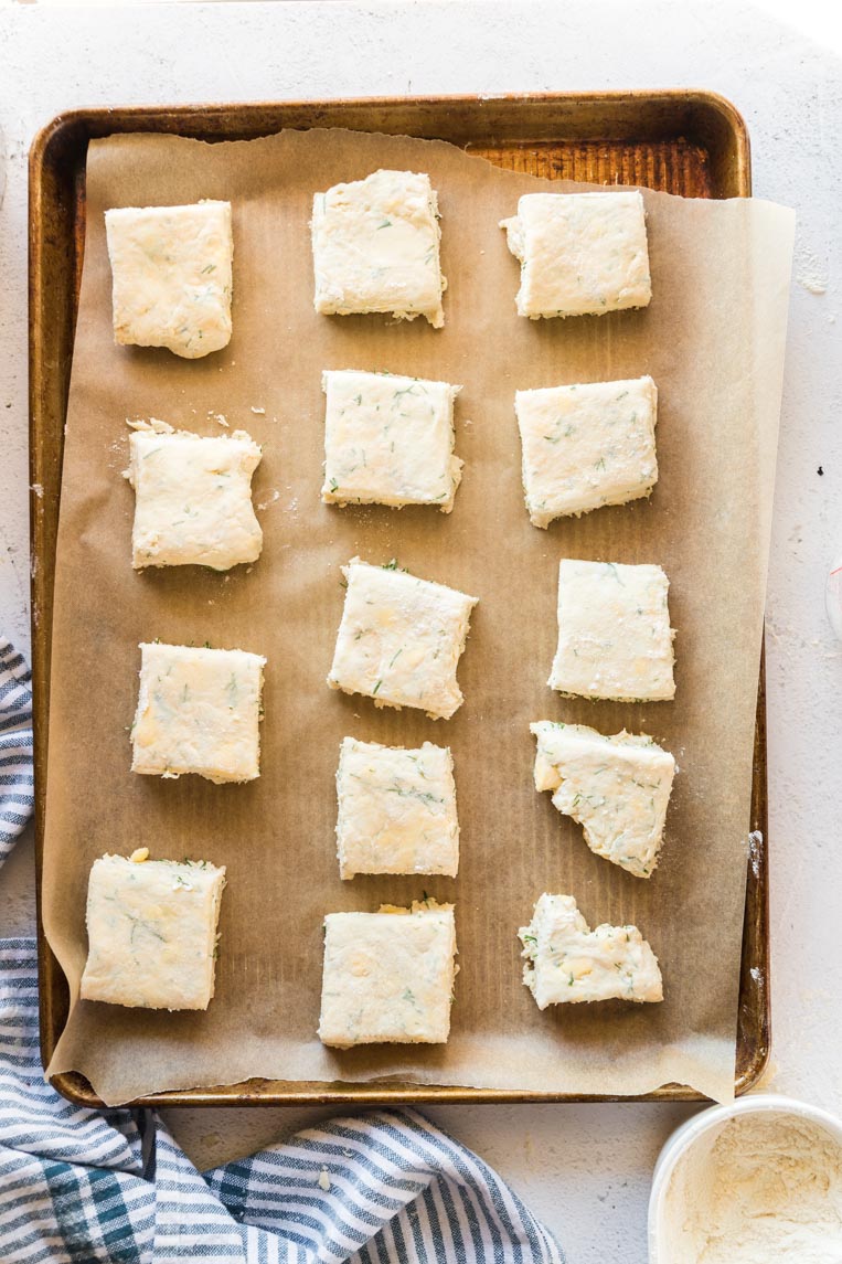 squares of cut biscuits on a cookie sheet before baking