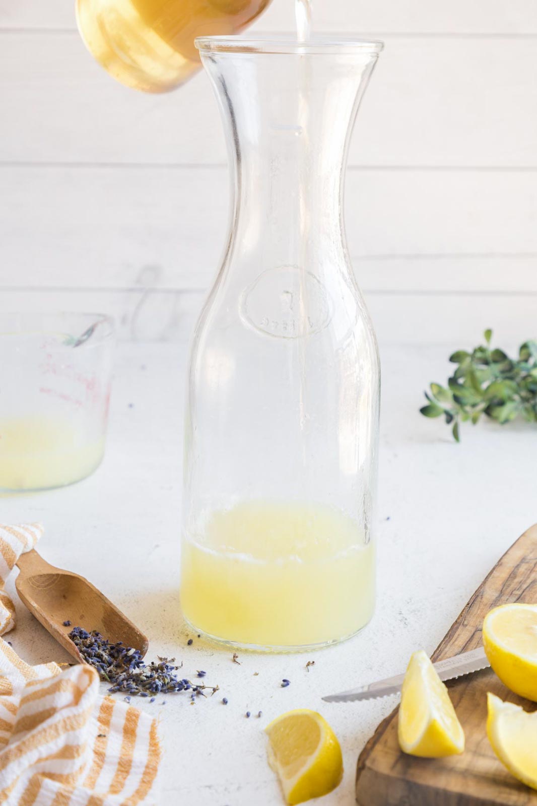 Pouring lavender simple syrup into freshly squeezed lemon juice.