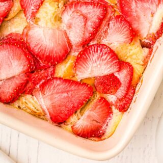 corner of a baking dish overlooking strawberries on top of casserole
