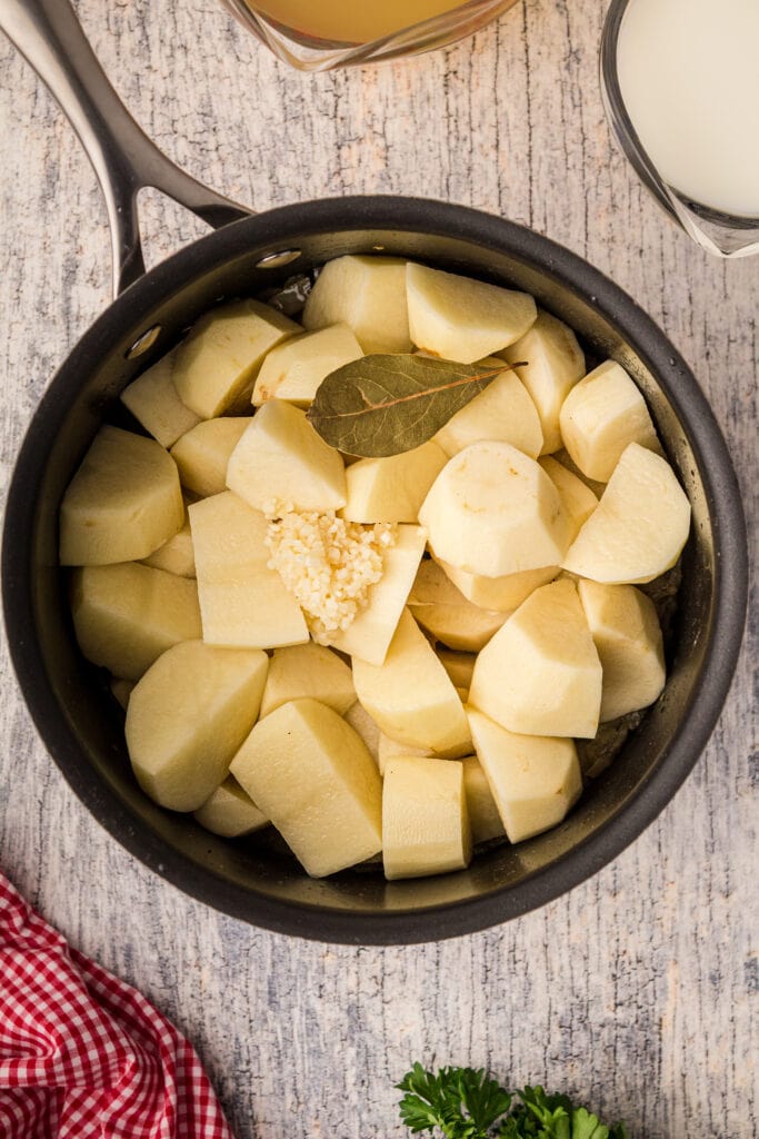 Diced potatoes, Bay leaf, garlic with the onions in a pot. 