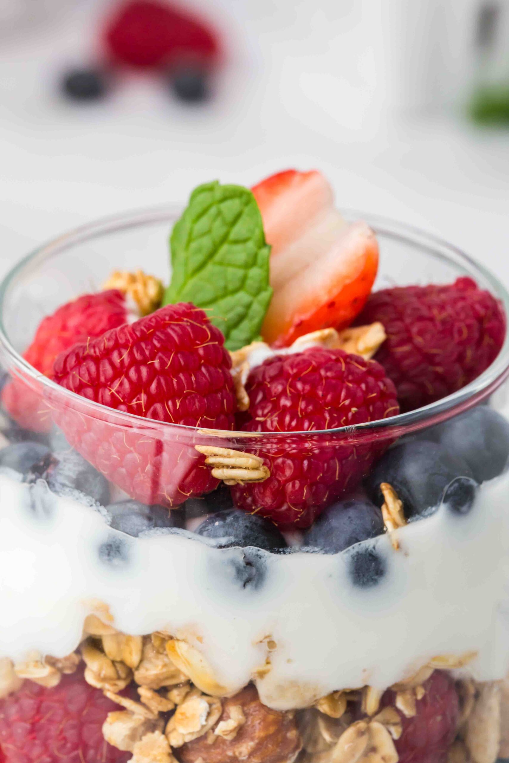 a close up of fruit on a yogurt parfait in a cup 