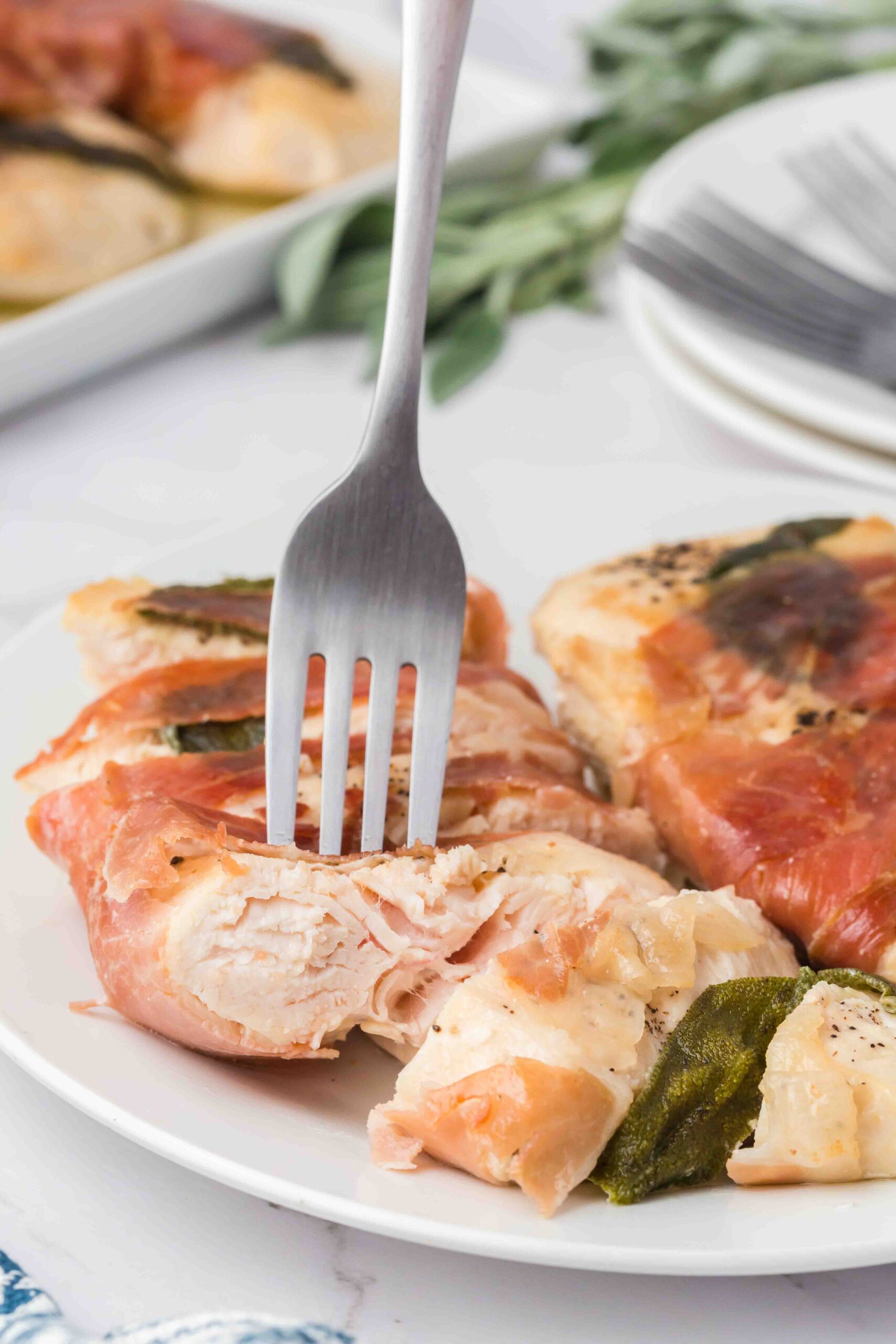 a slice of chicken saltimbocca with a fork in it 