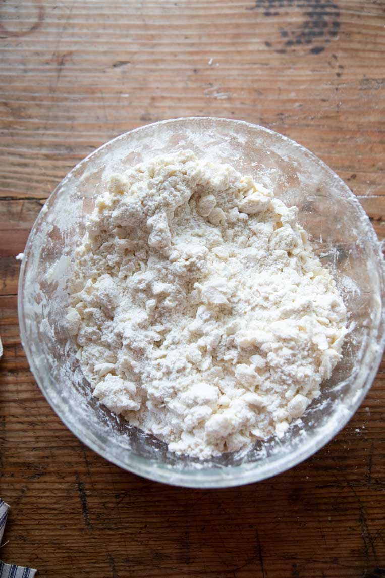 a bowl of flour with butter mixed in