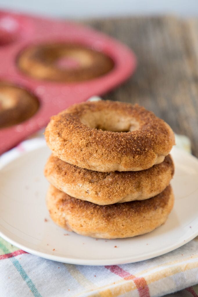three baked apple cider donuts on a plate