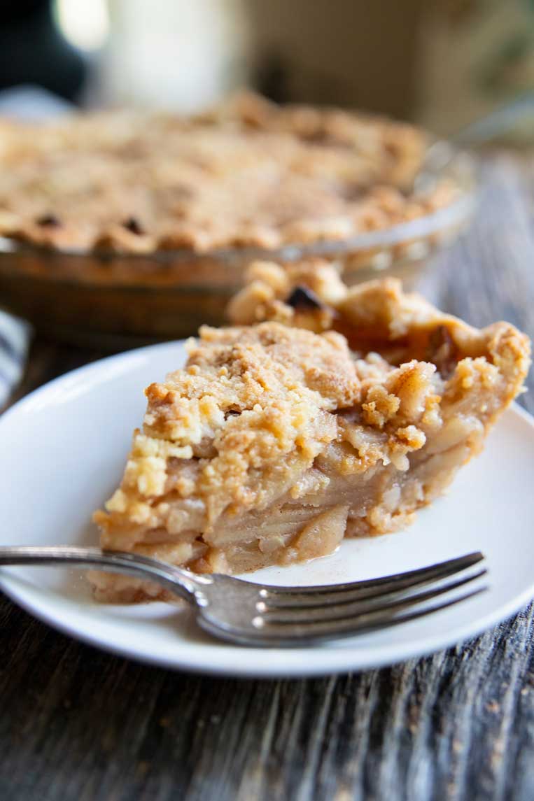a slice of apple pie on a plate with a fork