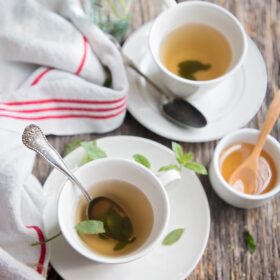 two cups of peppermint tea on a wooden table