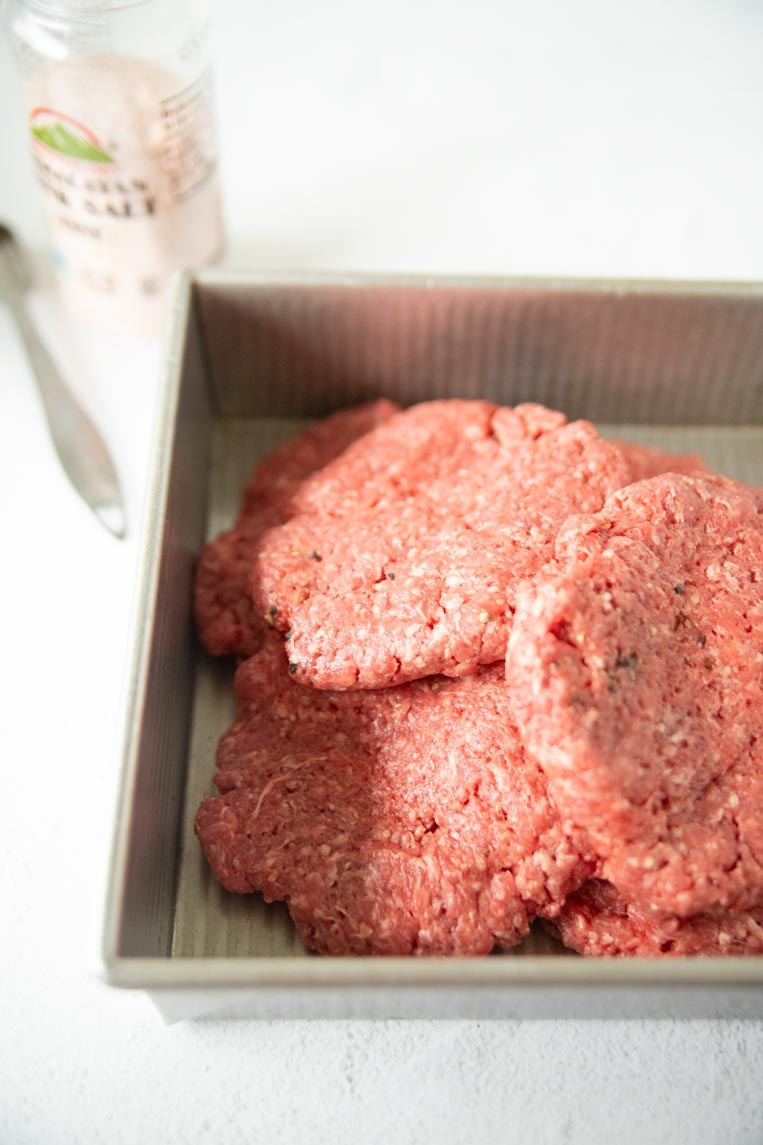 uncooked bison patties in a pan 