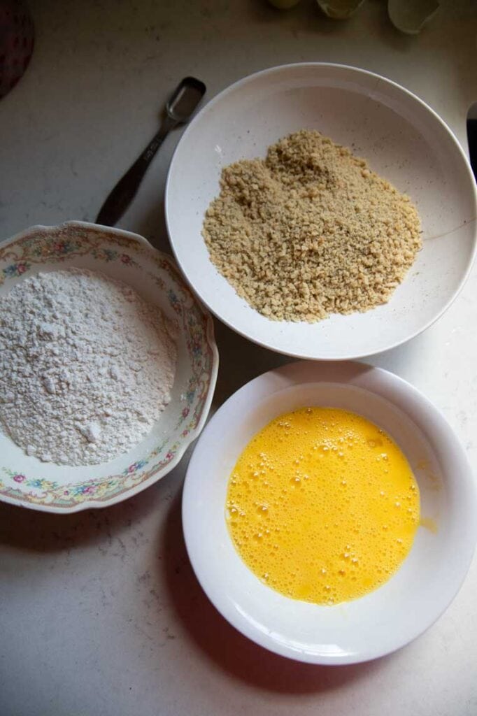 three bowls of breading for cheese sticks; flour, eggs, and bread crumbs