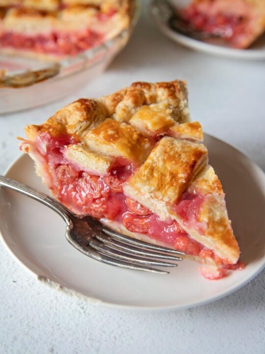 a slice of tart cherry pie on a plate with a fork