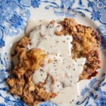 a chicken fried steak with gravy on a plate