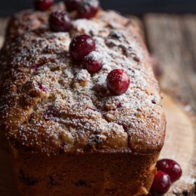 cranberry bread with walnuts and orange on a board