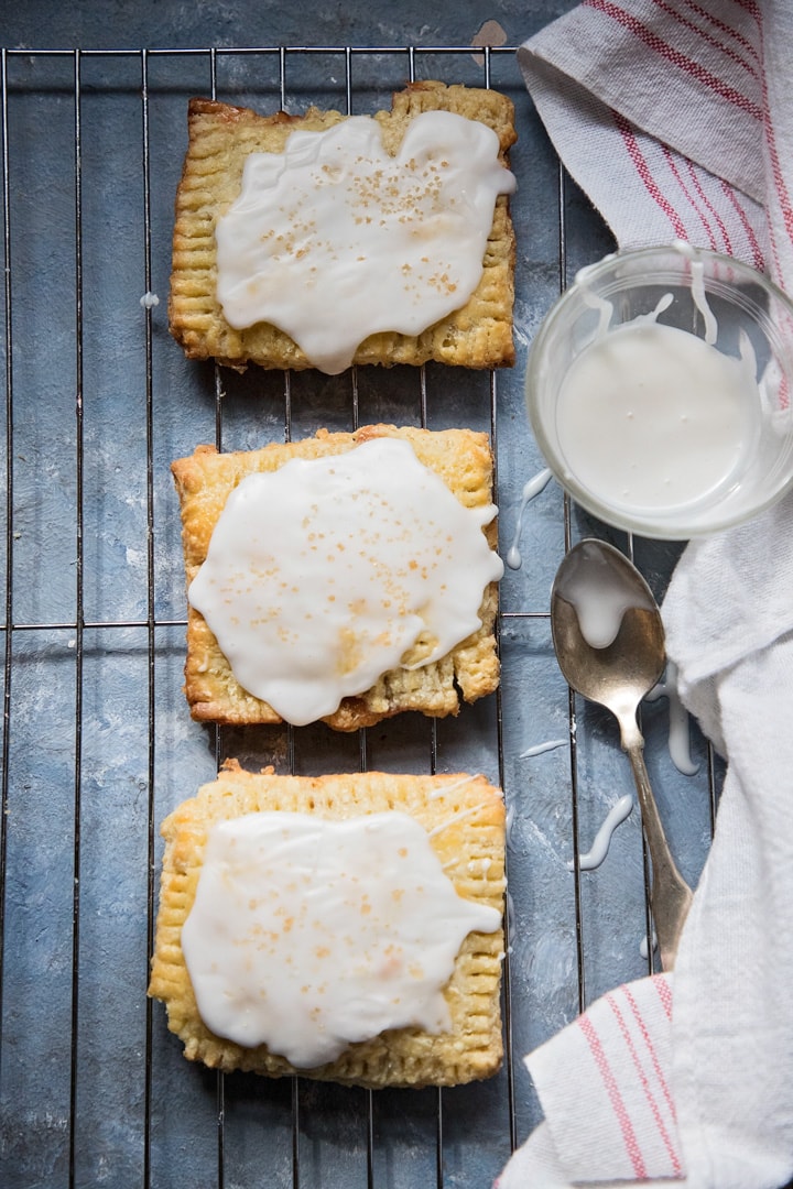 frosted strawberry pop tarts on a try with frosting and a spoon