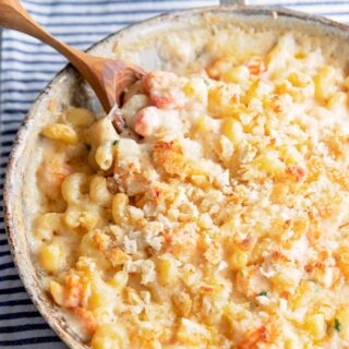 a skillet of lobster mac and cheese with a spoon