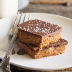 two almond butter bars stacked on top of each other on a plate