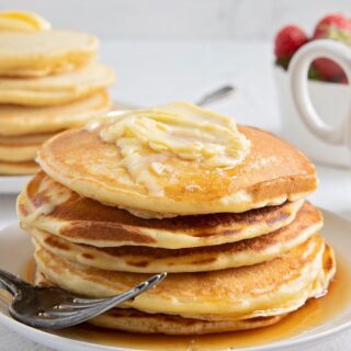 a stack of whole pancakes with syrup and butter on a plate