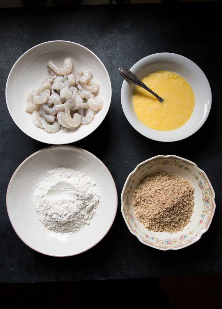 four bowls of breading ingredients