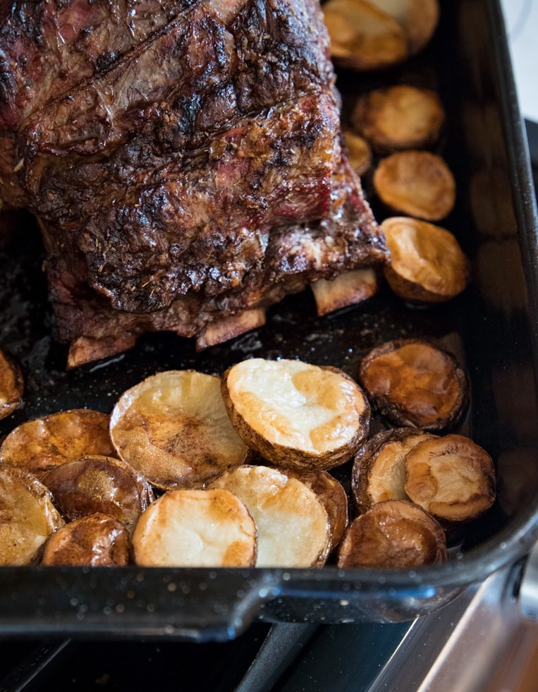a pan of potatoes roasted in the pan to roast with the rib cooked