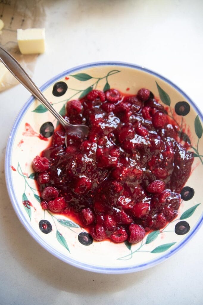 a bowl of raspberries mashed with jam
