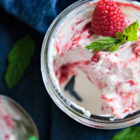 a jar of raspberry fool with a scoop out of it