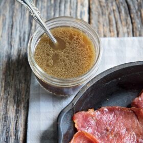 red eye gravy in a jar with a spoon ready for country ham in a skillet