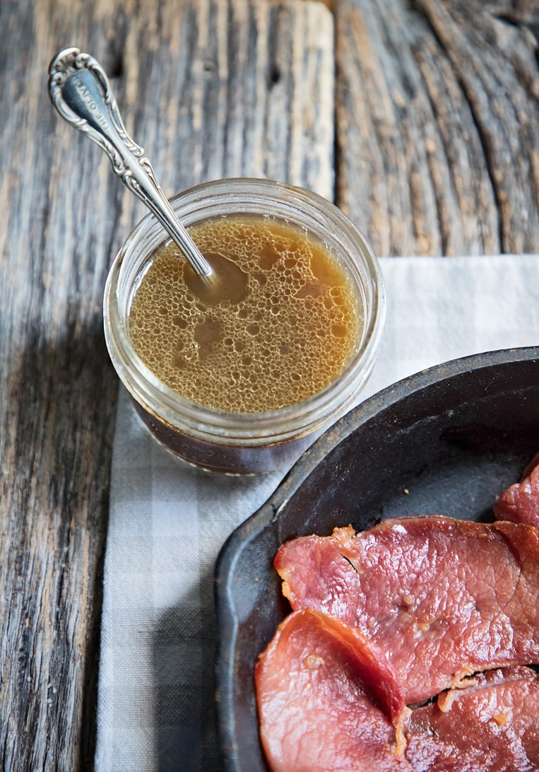 red eye gravy in a jar with a spoon ready for country ham in a skillet
