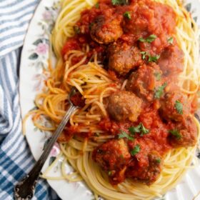 a big platter of spaghetti and meatballs with a fork