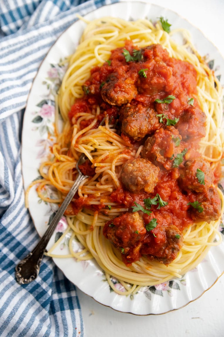 a big platter of spaghetti and meatballs with a fork