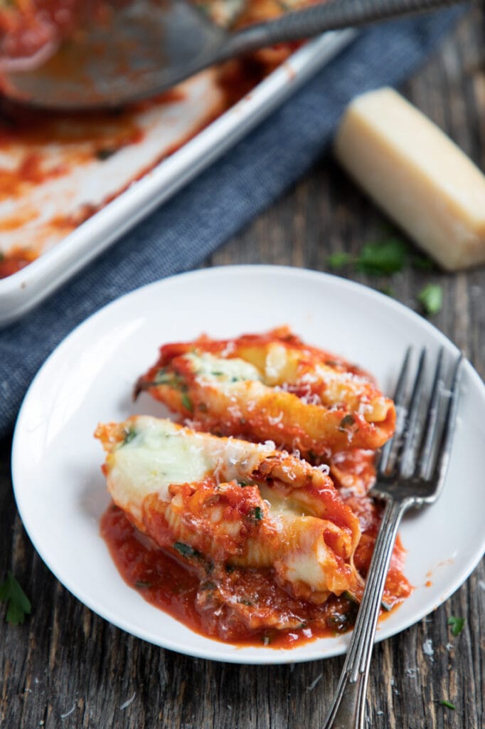 two stuffed shells on a plate with a fork